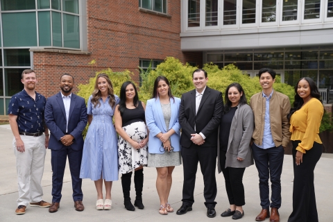 Group photo of nine Georgia Tech alumni standing in a row outside of a building